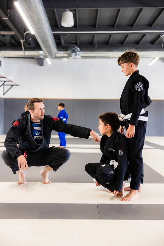 Adam Schmaltz coaches two students in gis
