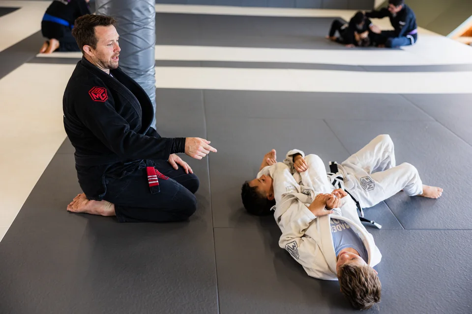 A coach explains a position to two students in gis