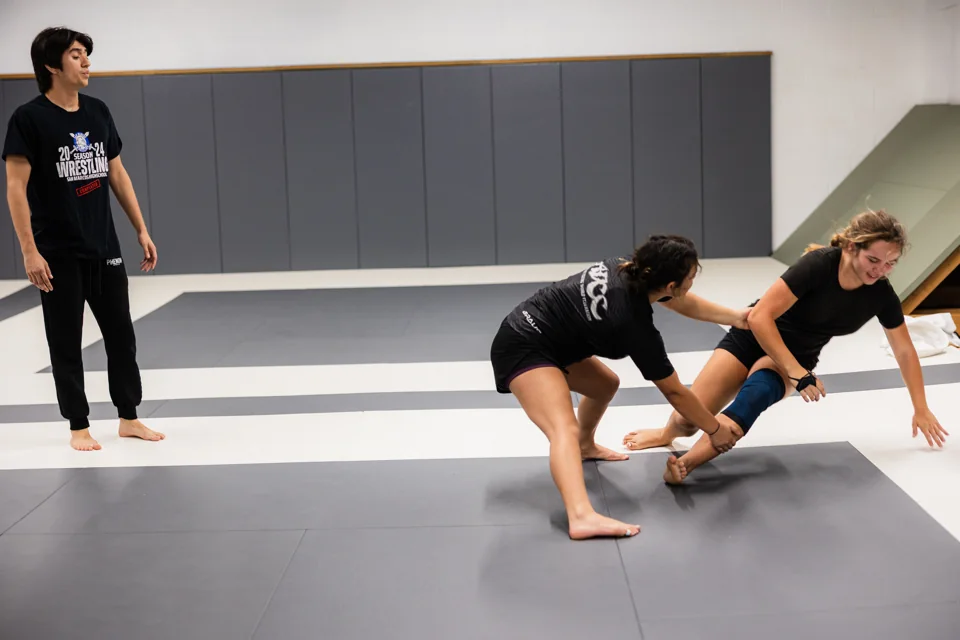 Two students drill a takedown on the mats