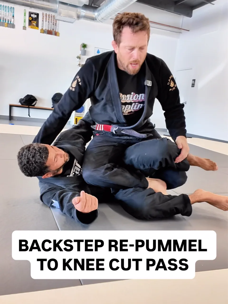Two students drill a knee cut pass during gi training