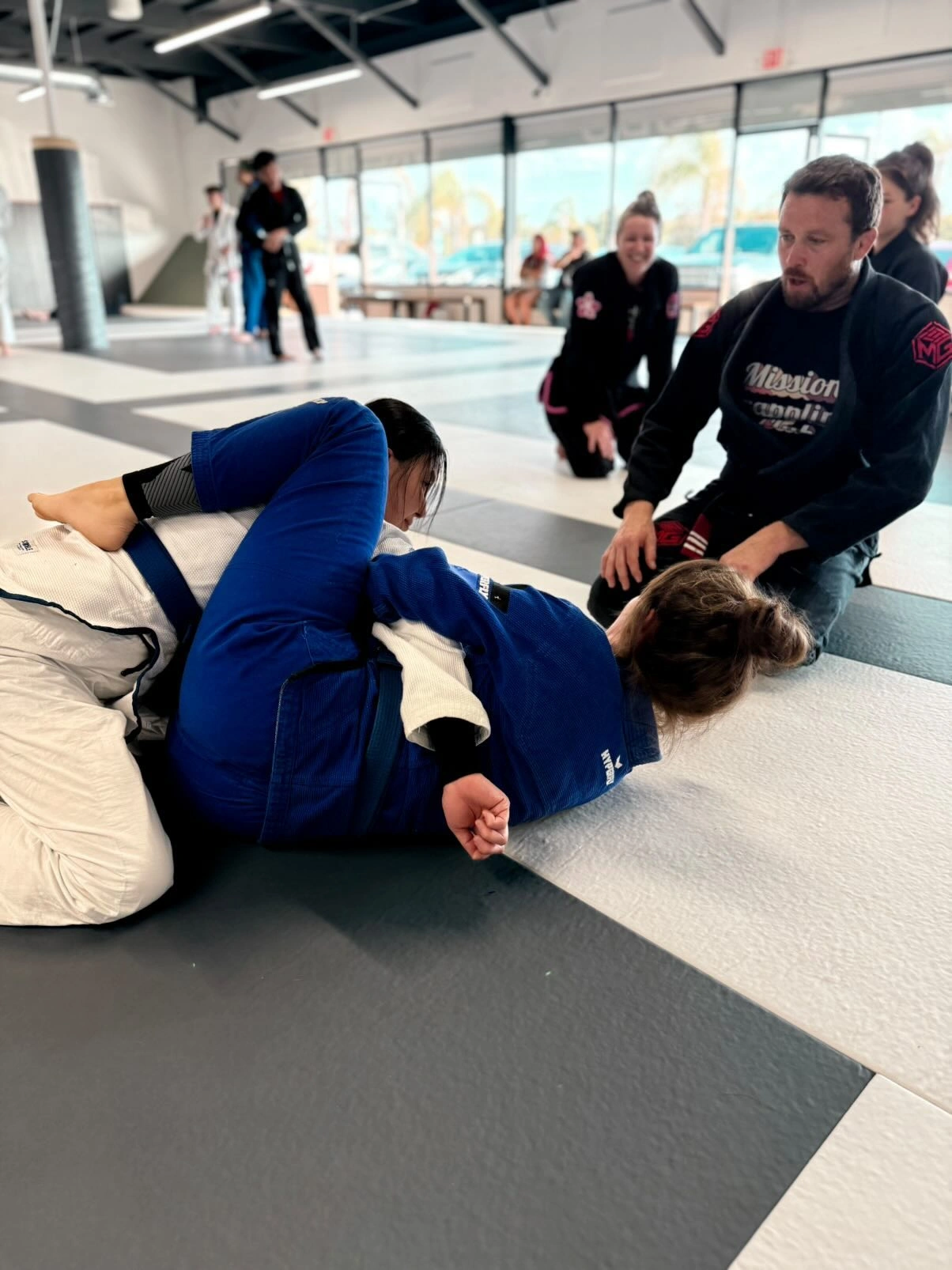 Young students learning a grappling technique with a coach